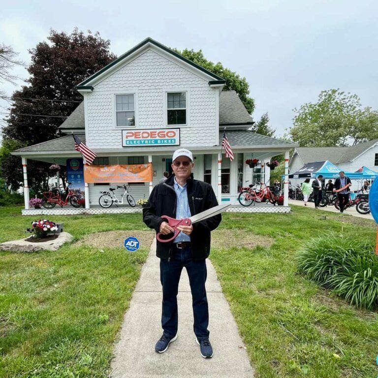 Owner of Pedego Groton, Paul Ward, standing outside of his storefront.