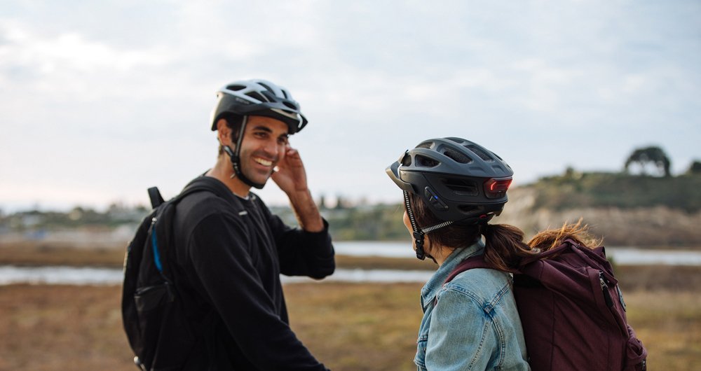 Two people laughing while wearing Sena bluetooth helmet.