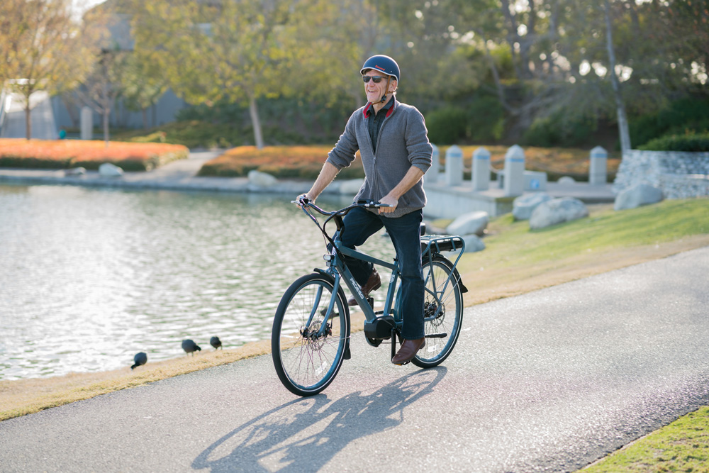 Man riding his Pedego City Commuter in the park.