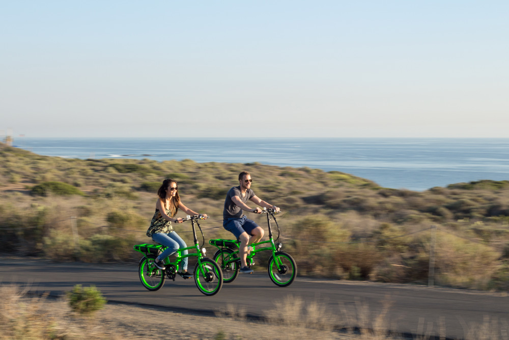 Couple riding the Pedego Latch on a road.